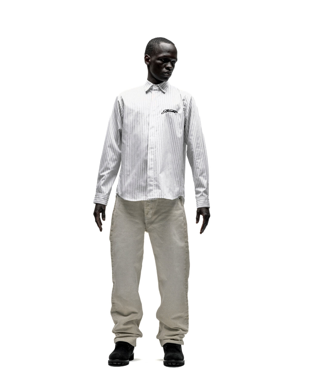 Man in white 5-pinstripe woven cotton oxford button-down shirt with embroidered script logo and light pants.