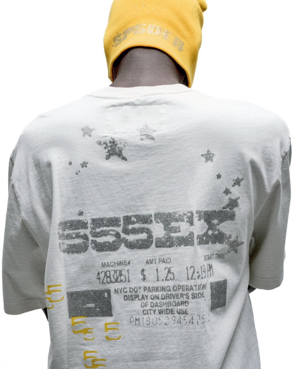 White cotton ANNIVERSARY TEE with gray graphic print of "555EX" and parking ticket details on the back.