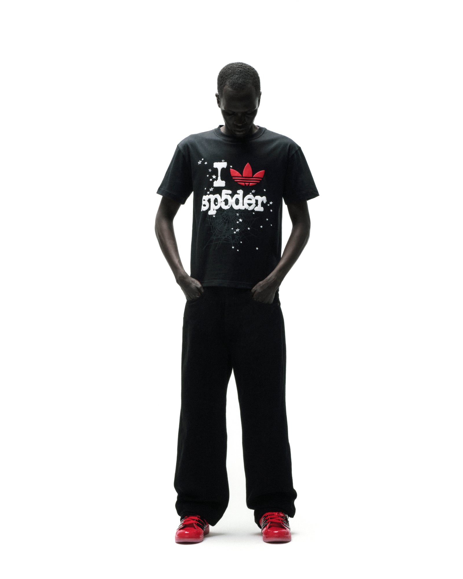 Black Adidas Souvenir Tee with red Trefoil and "I SP5DER" graphic, worn by a model.