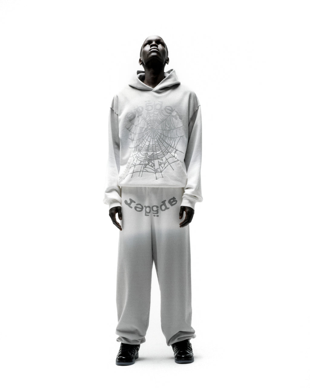 Model wearing an OG WEB OMBRE HOODIE and matching sweatpants with a spiderweb graphic.