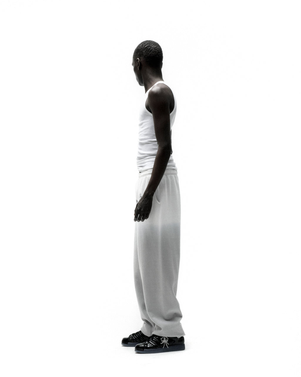 Man in white tank top and OG WEB OMBRE SWEATPANT with subtle ombre design and 'SP5DER' text.