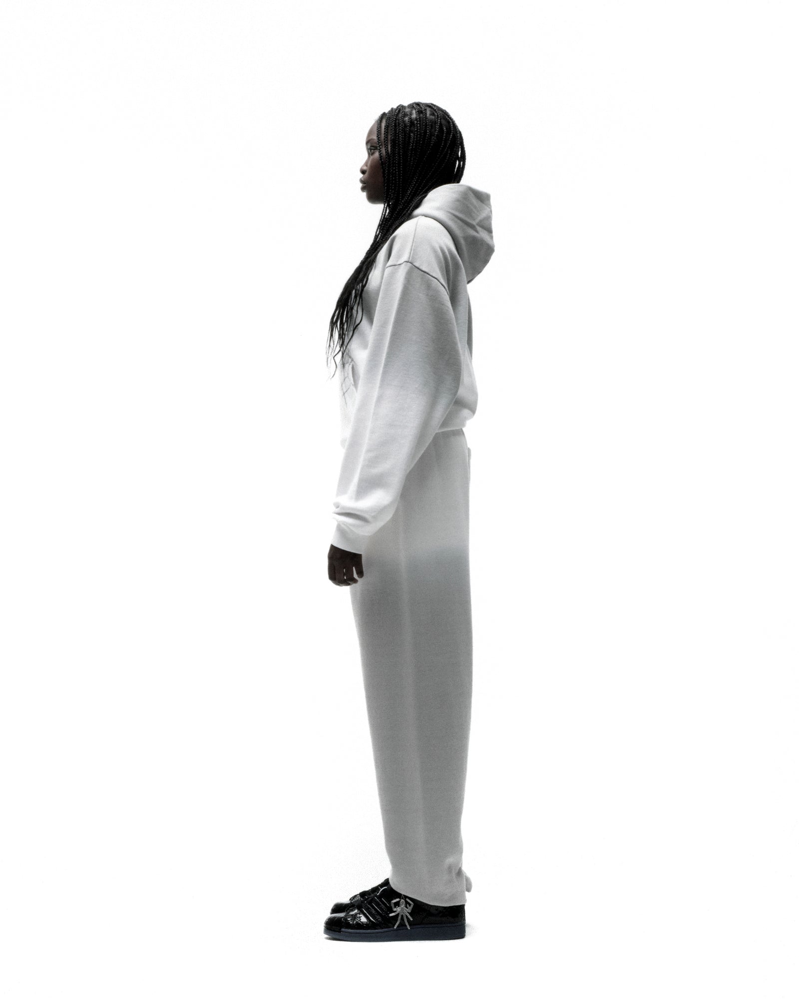 Model in white OG WEB OMBRE SWEATPANT and matching hoodie, side profile.