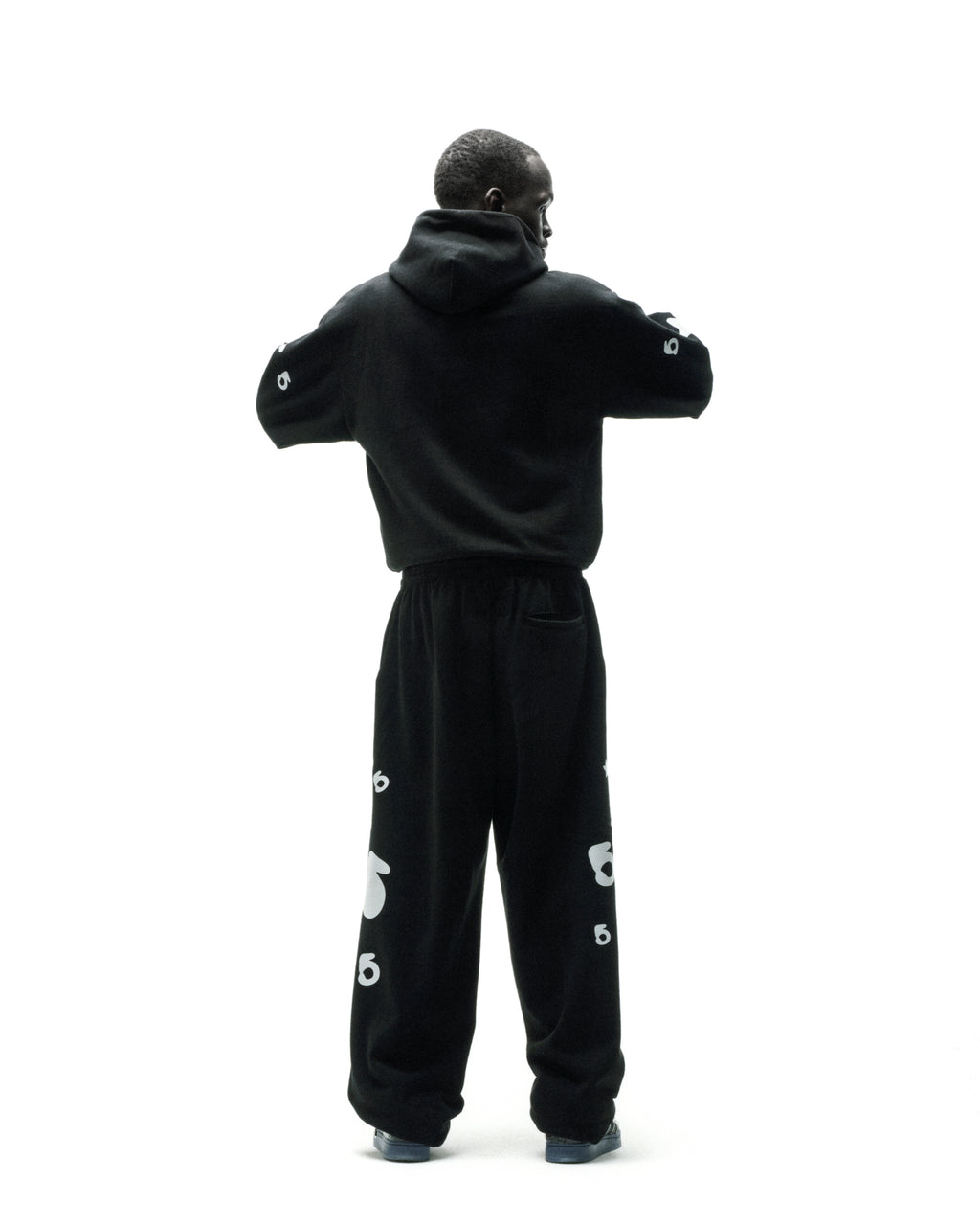 Black cotton fleece hoodie and sweatpants with reflective 'SP5DER' and star print.