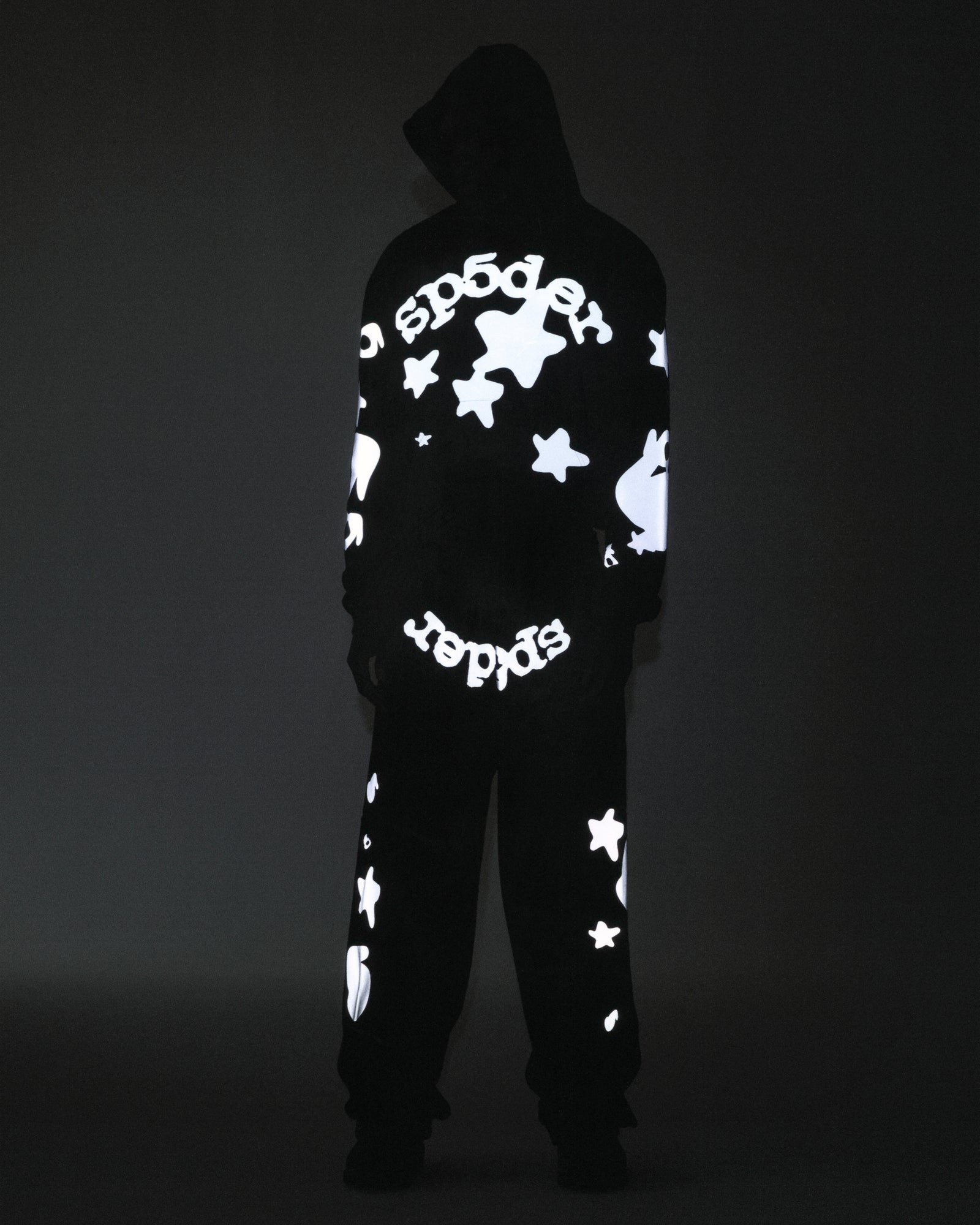 Black cotton fleece hoodie and sweatpants with reflective 'SP5DER' text and star prints.