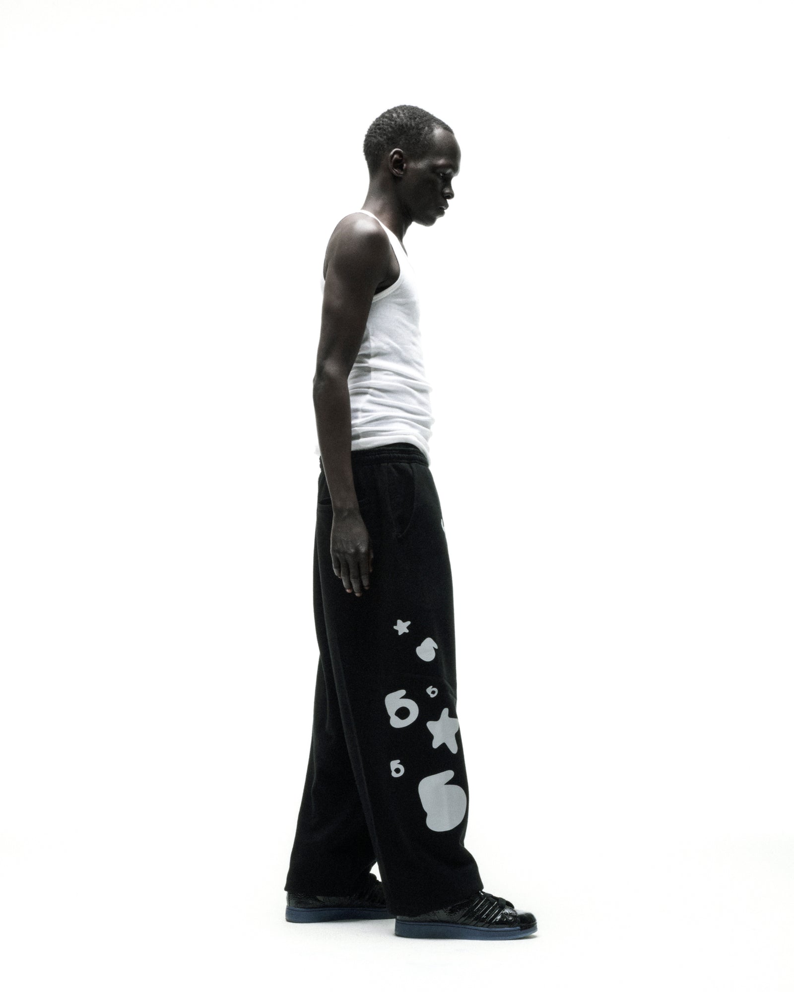Black wide-leg cotton fleece sweatpants with reflective 'SP5DER' text, '5' and star designs.
