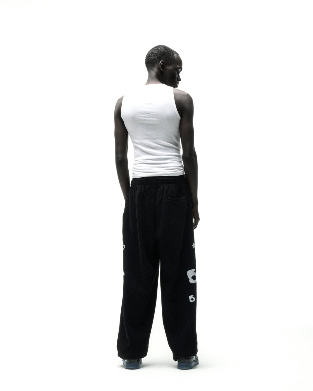 Black 13oz cotton fleece sweatpants with reflective 'SP5DER' text, '5', and star designs.