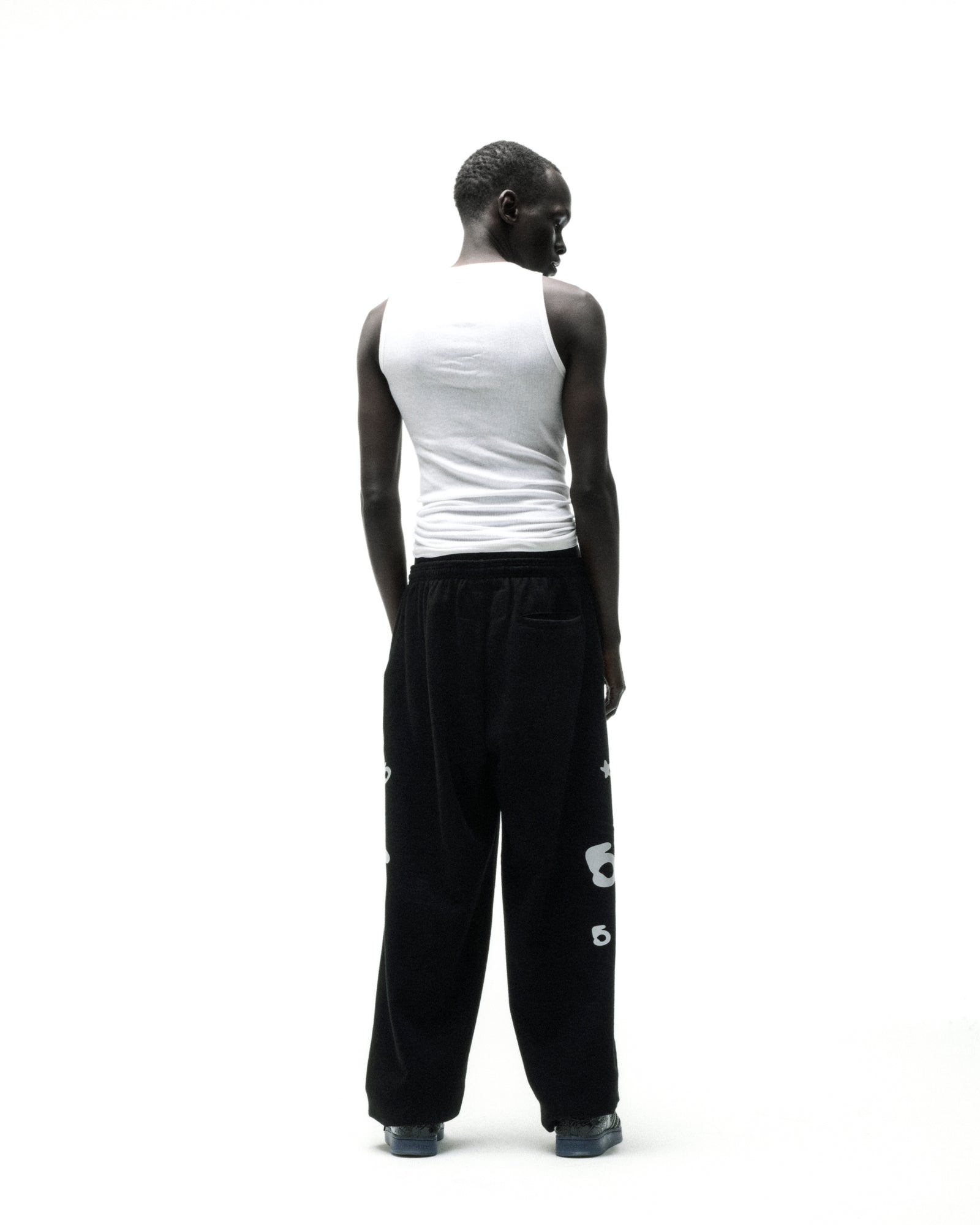 Black 13oz cotton fleece sweatpants with reflective 'SP5DER' text, '5', and star designs.