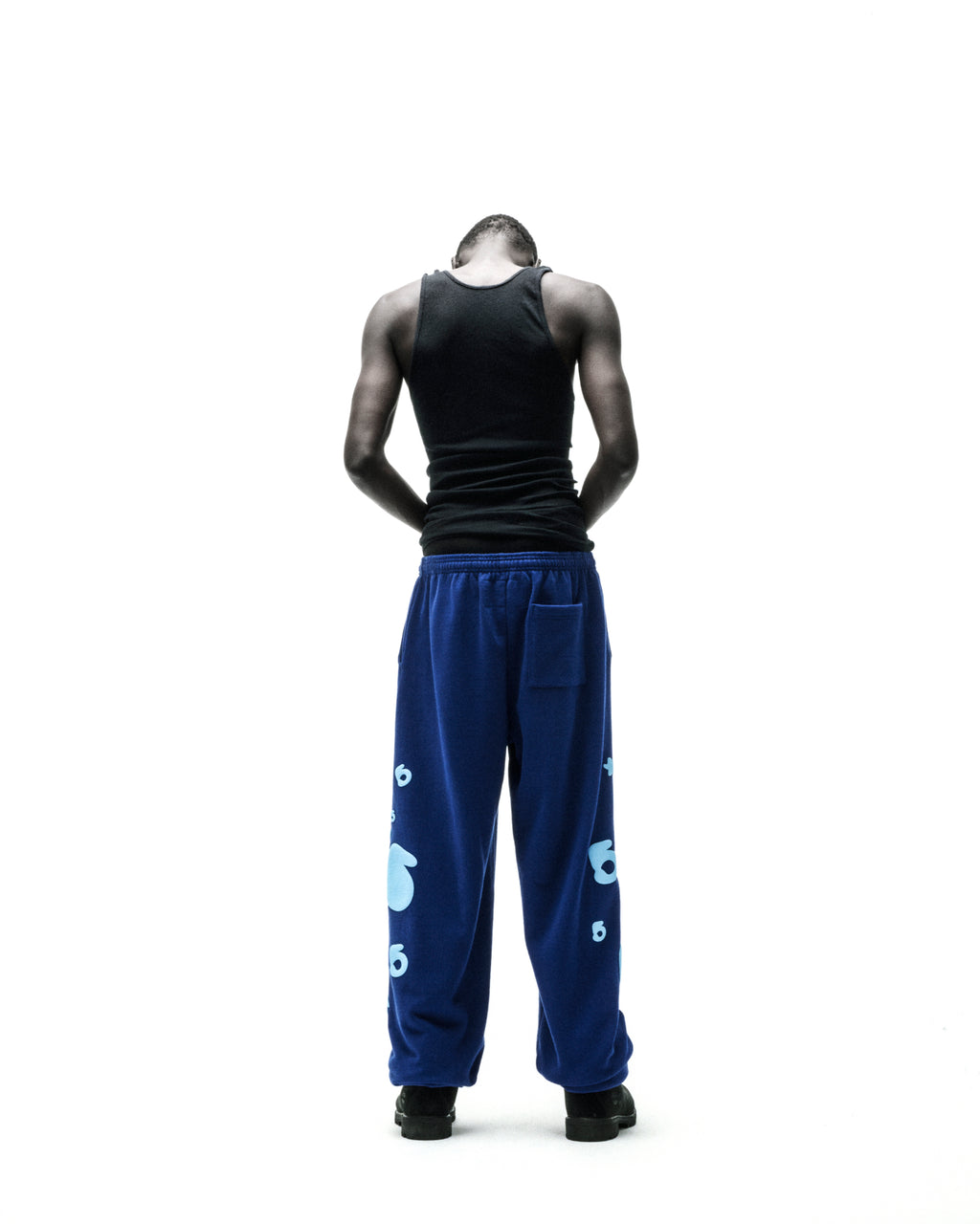Blue Beluga V2 sweatpants with light blue puff print "5" and star designs, worn by a person from behind.