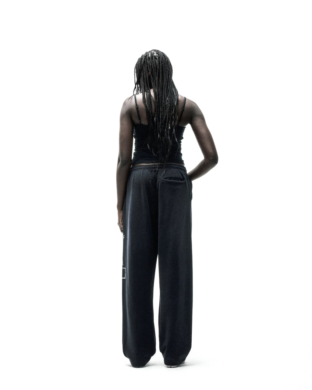 Black ISSUE 404 wide-leg sweatpants with faded graphic print, worn by a person facing away.
