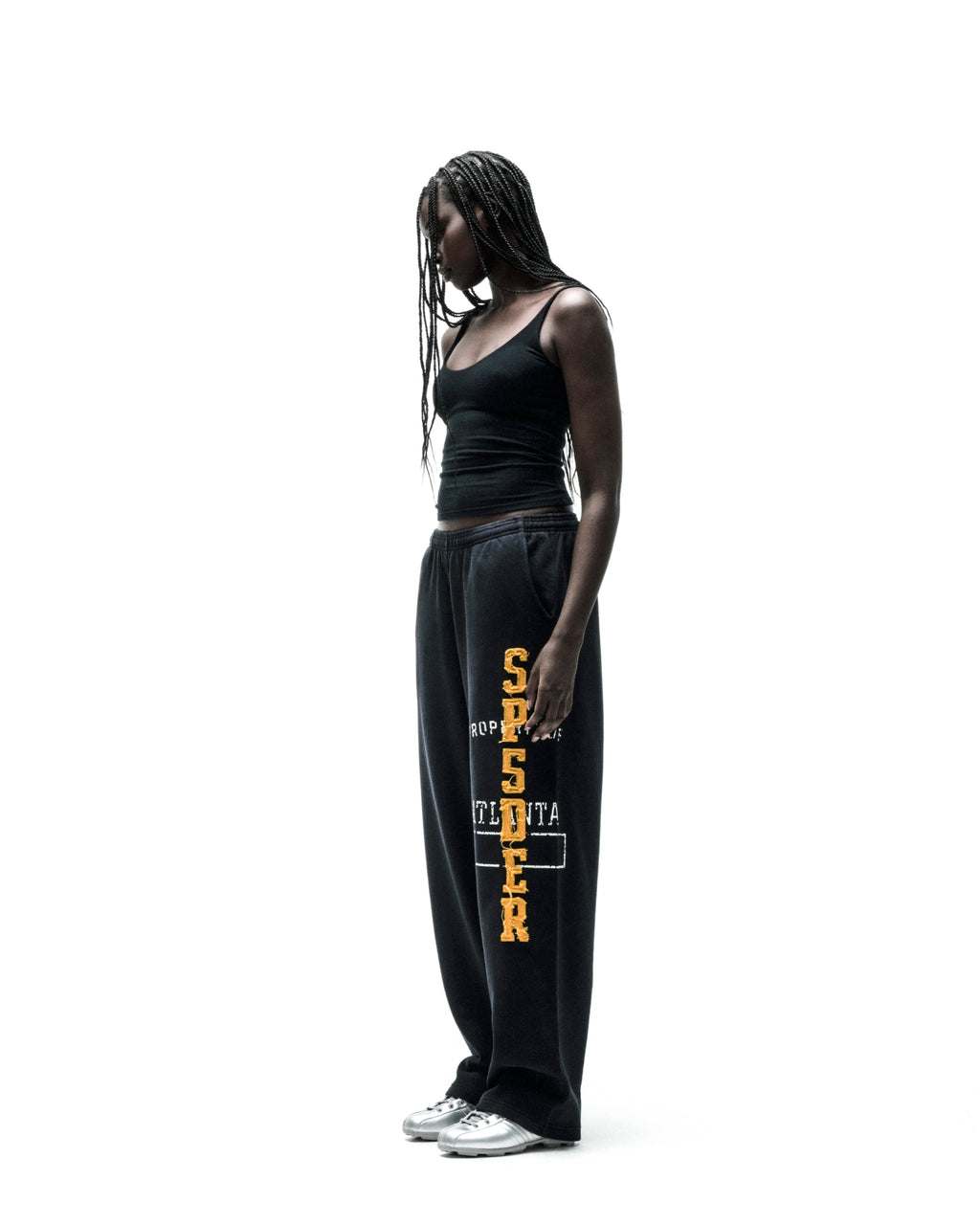 Black cotton fleece sweatpants with yellow chenille "SPIDER" lettering and frayed edges.