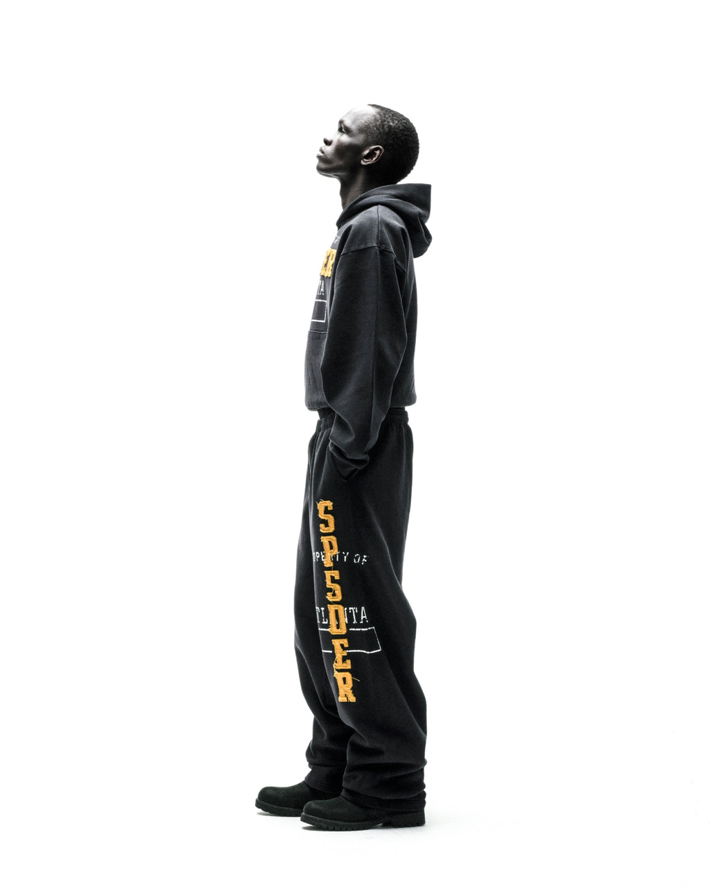 Black cotton fleece hoodie and sweatpants with raised chenille-style "SPSDER" lettering and frayed edges.