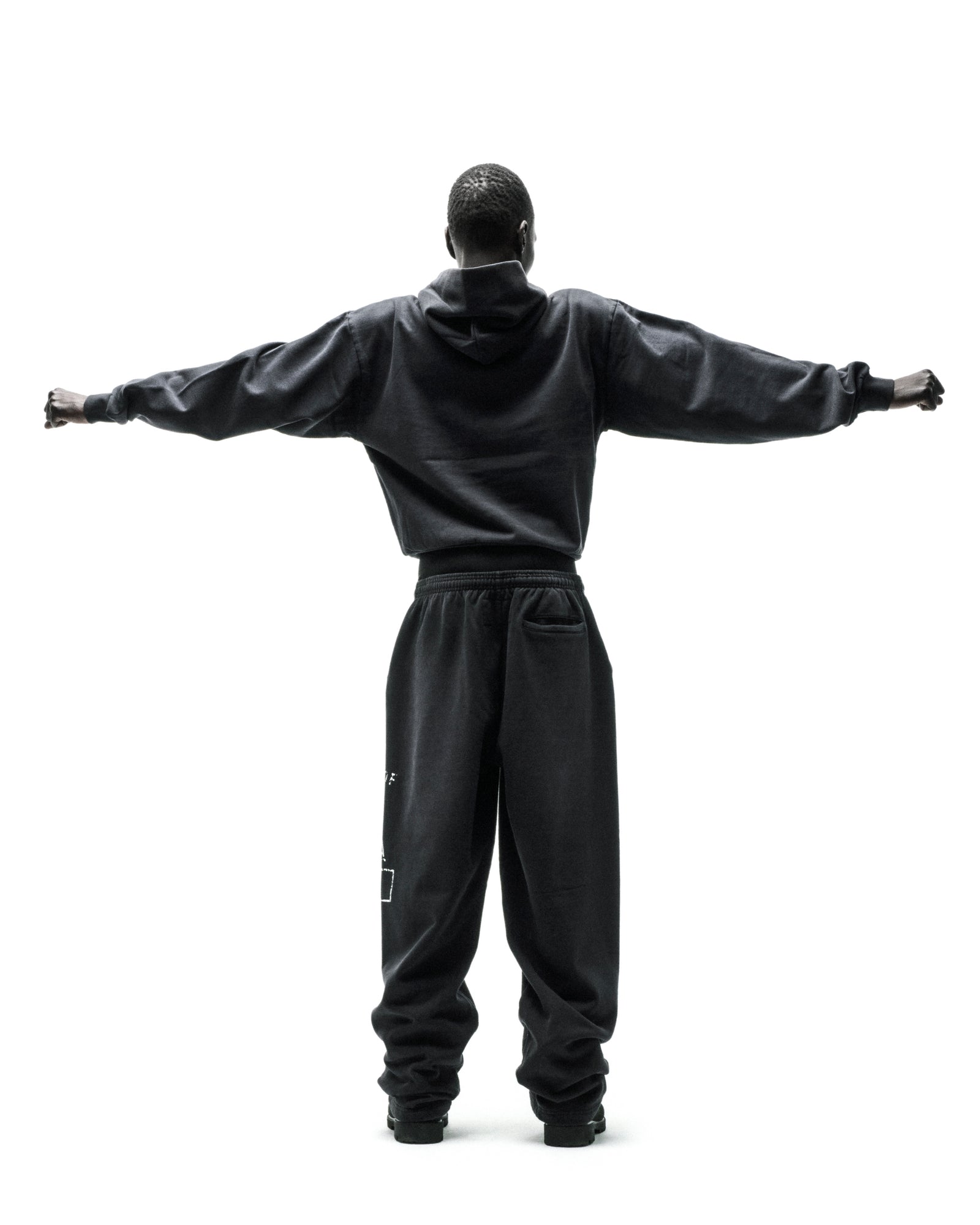 Dark grey cotton fleece hoodie and sweatpants with faded graphics and frayed lettering.