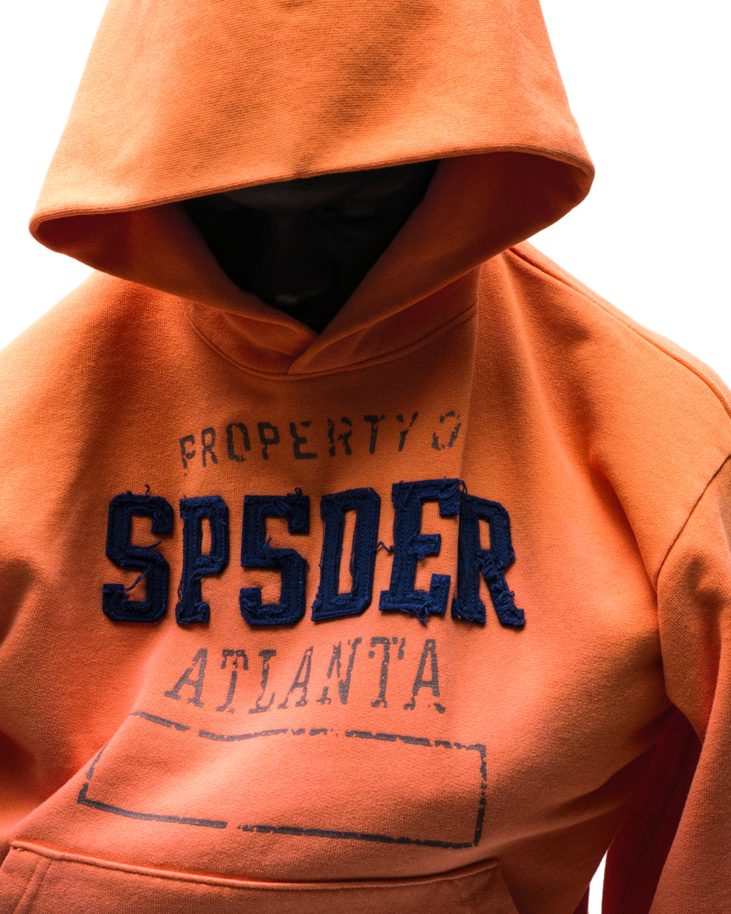 Orange cotton fleece hoodie with raised, frayed "SPSDER" lettering and faded graphic print.