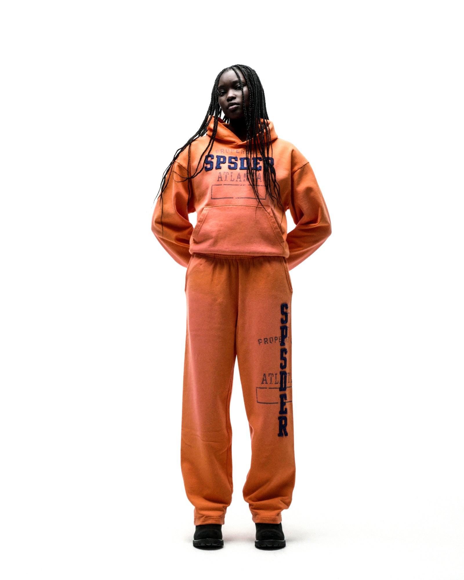 Orange cotton fleece hoodie and sweatpants with faded blue "SPSDER" lettering and frayed edges.
