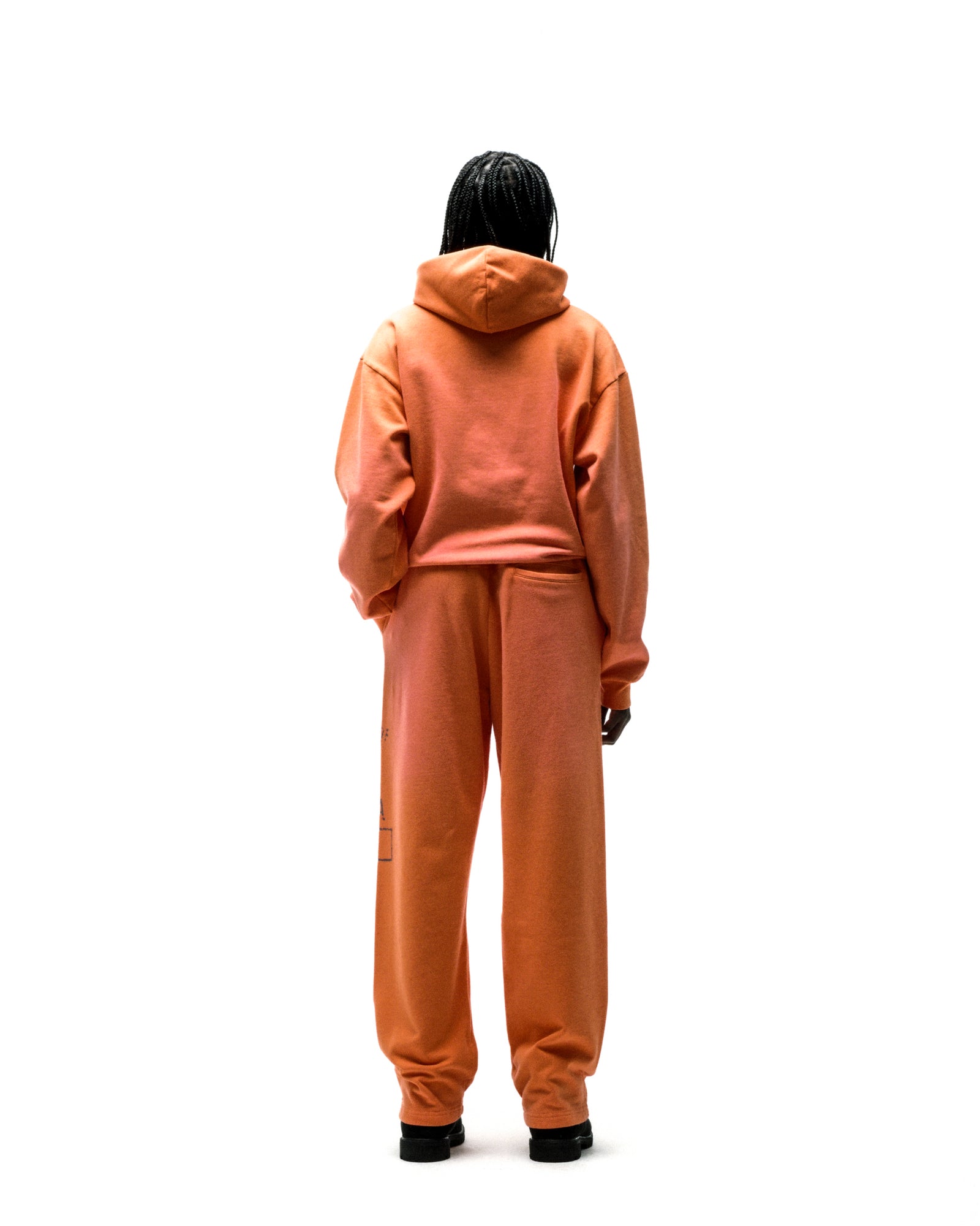 Orange cotton fleece hoodie and sweatpants set with faded graphic print.
