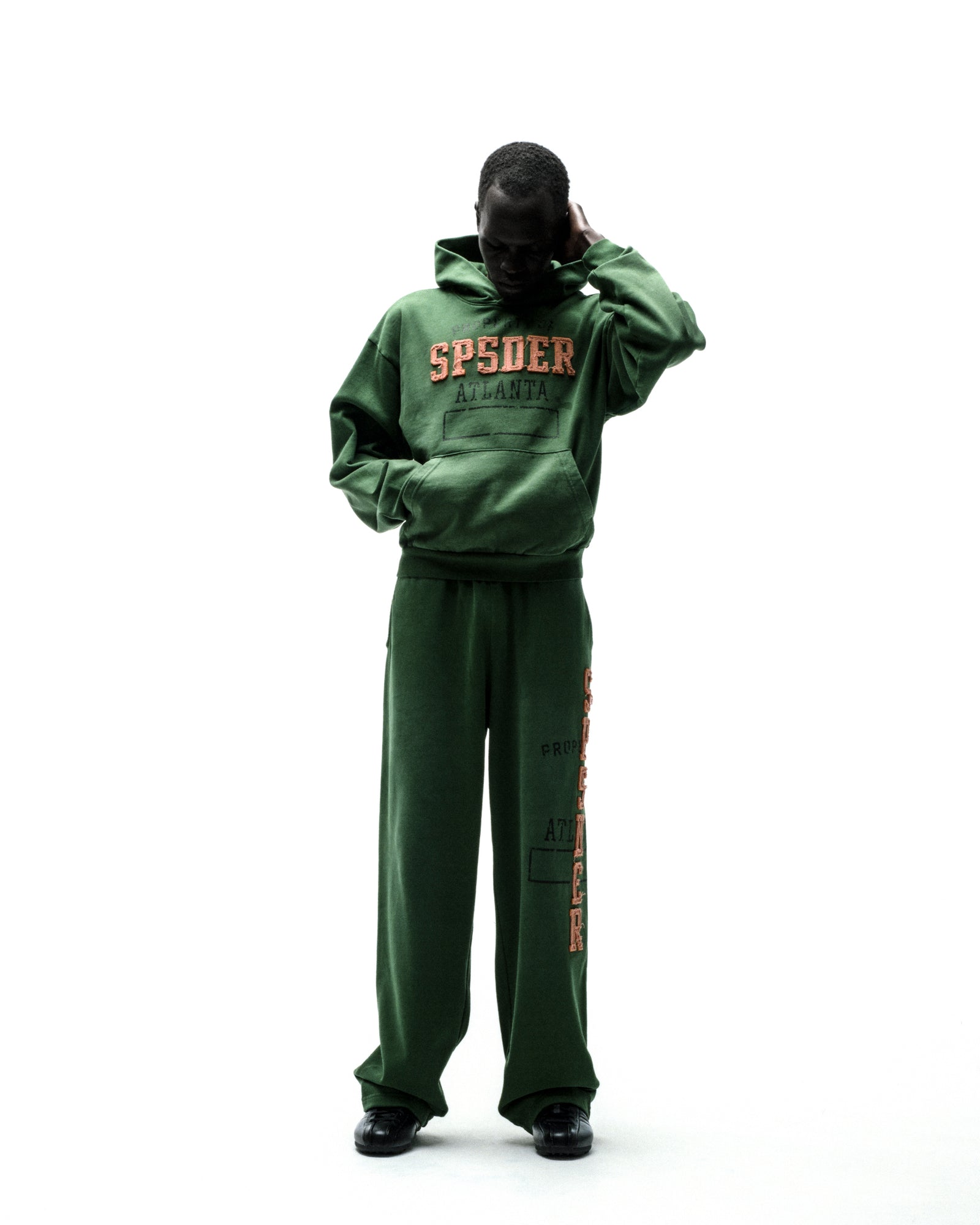 Dark green fleece hoodie with raised orange "SPSDER ATLANTA" lettering and matching sweatpants.