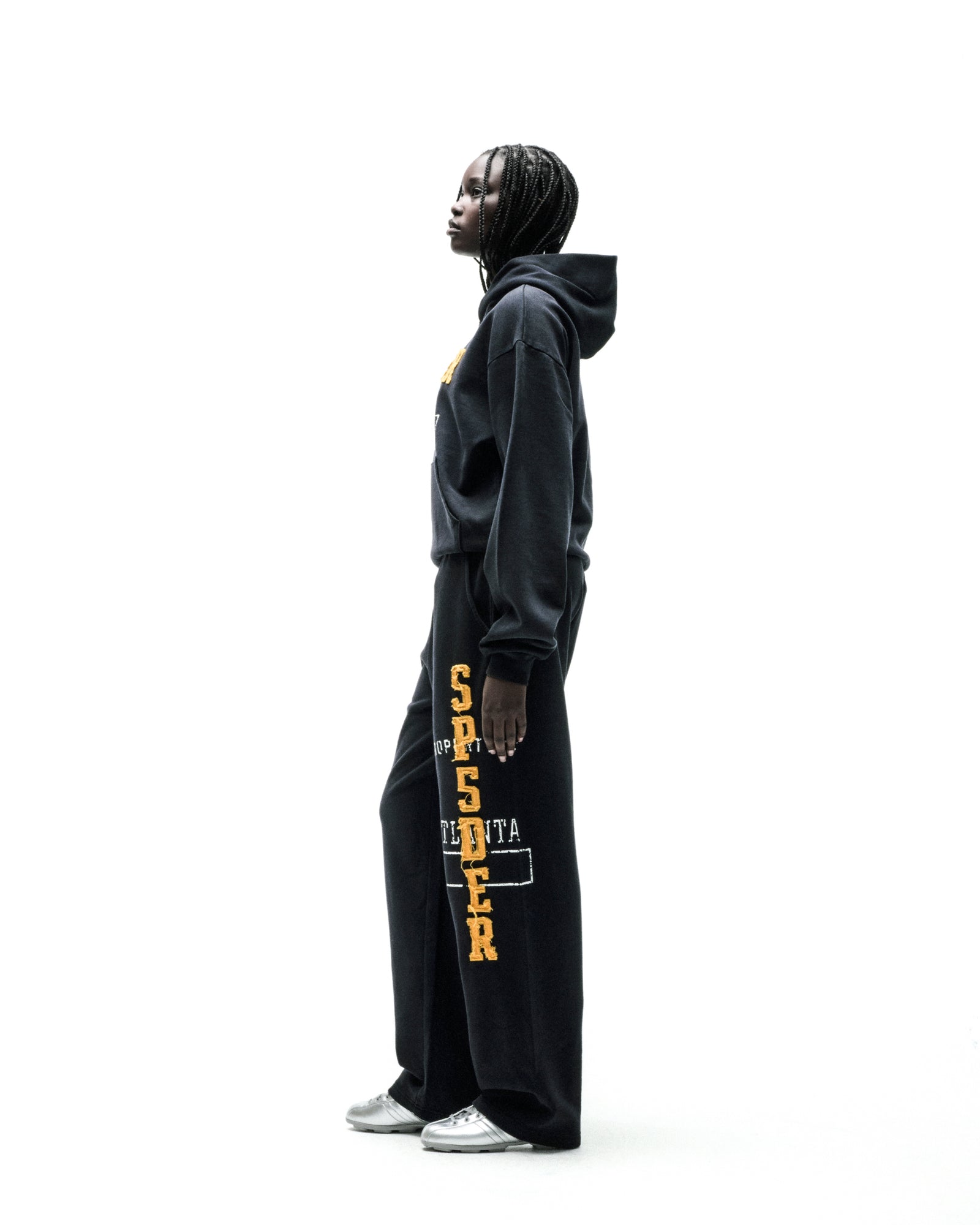 Black cotton fleece hoodie with faded yellow "SPSDER" lettering and frayed edges.