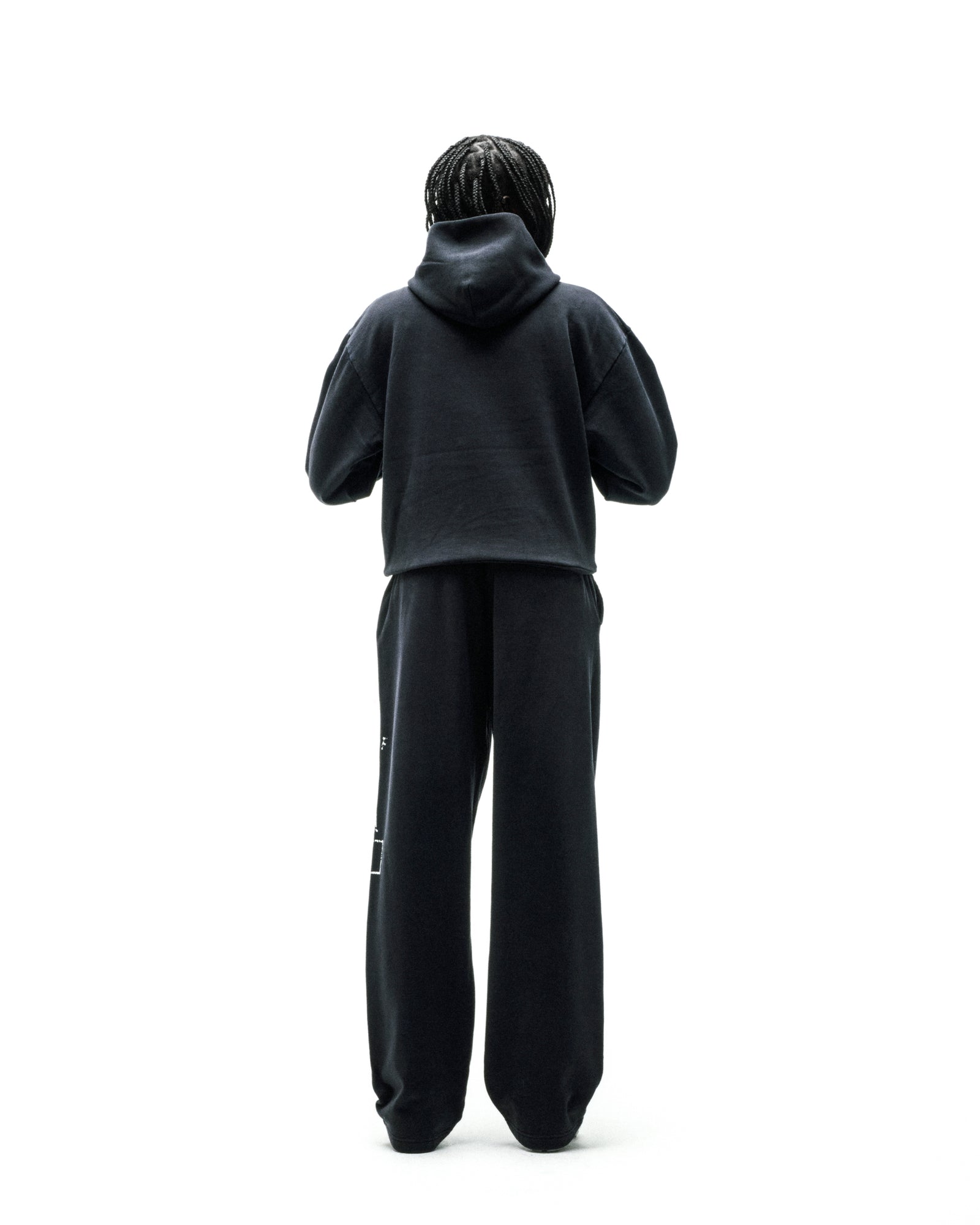 Black cotton fleece hoodie and sweatpants set, worn by a person from behind.