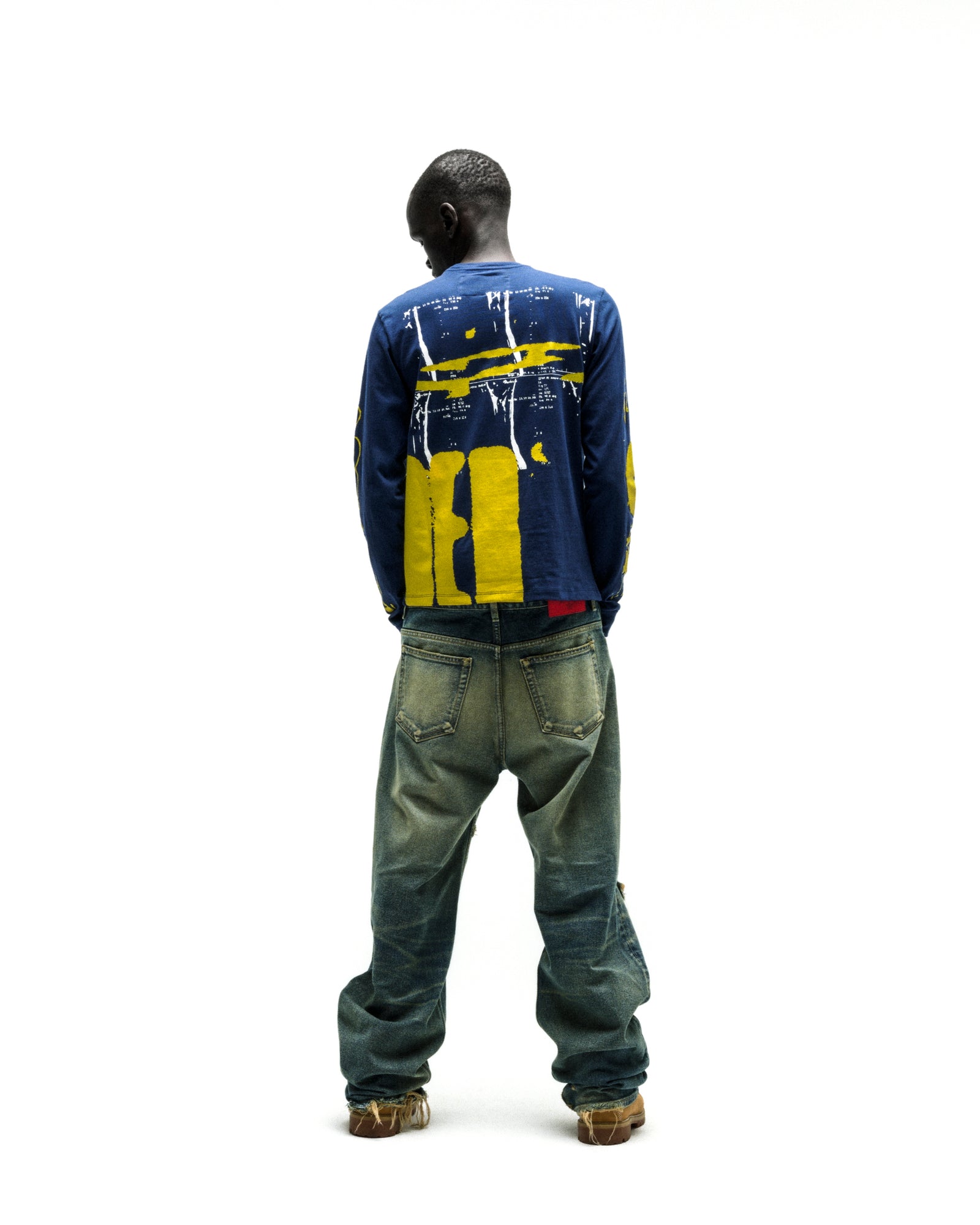 Man in a navy blue X-RAY LONGSLEEVE cotton tee with yellow graphic print on back and sleeves.