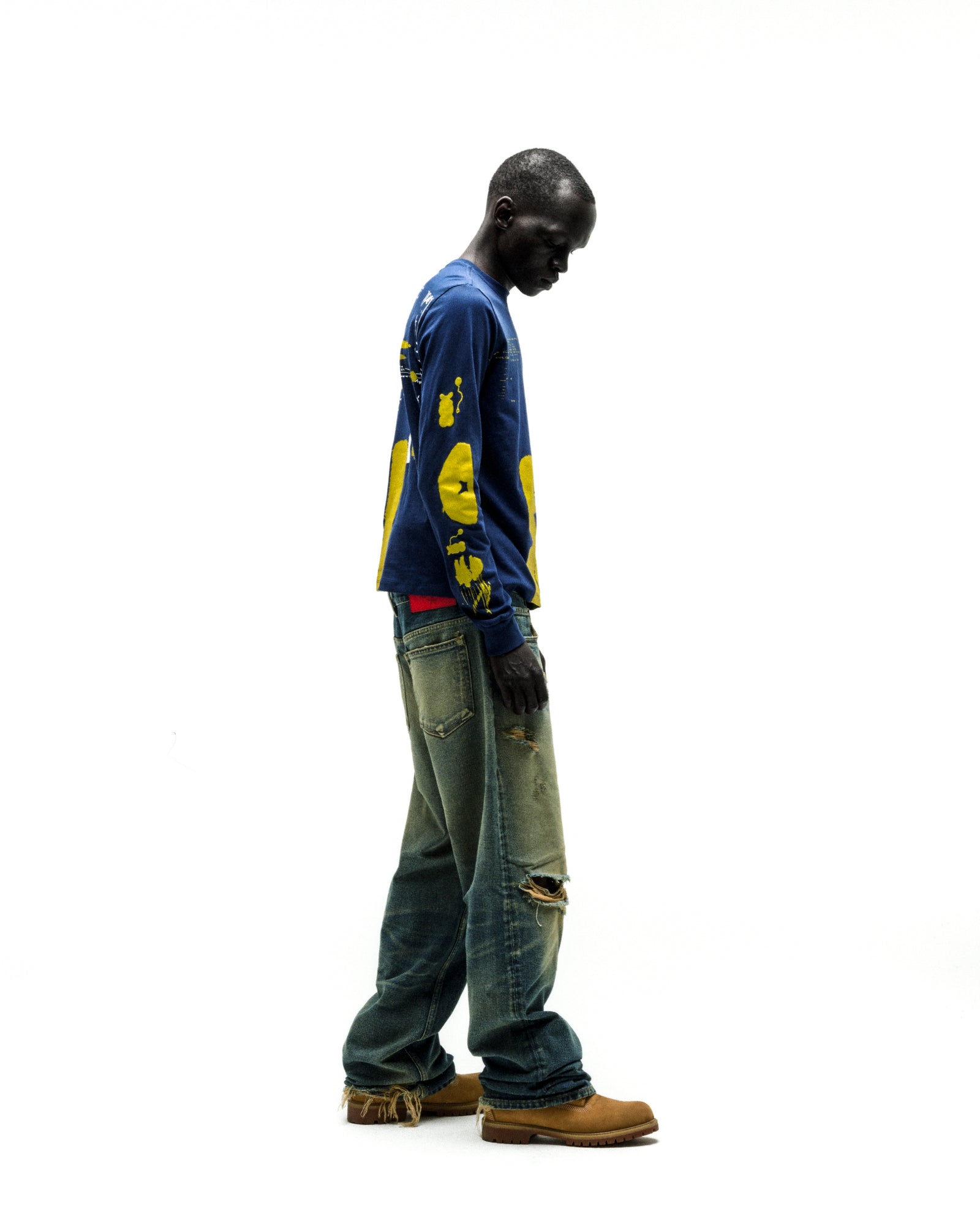 Model wearing a navy blue 100% cotton X-RAY LONGSLEEVE with yellow graphic print on front, back, and sleeves.