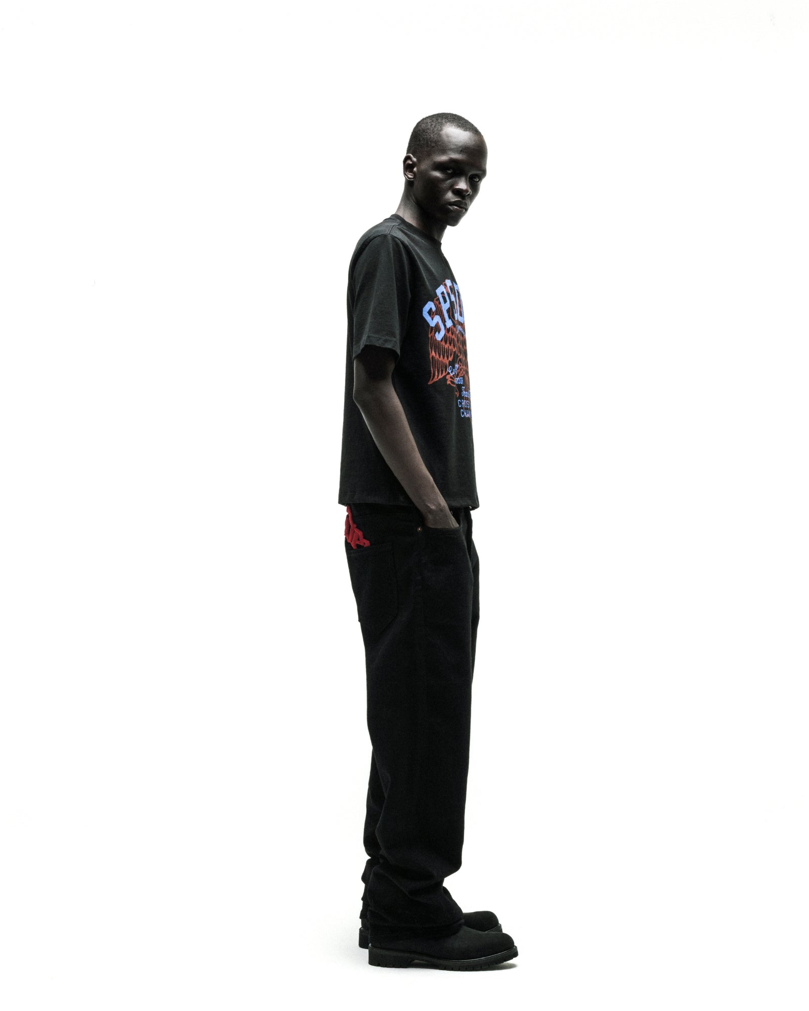 Black Champions League tee with a colorful graphic, paired with black jeans and shoes.