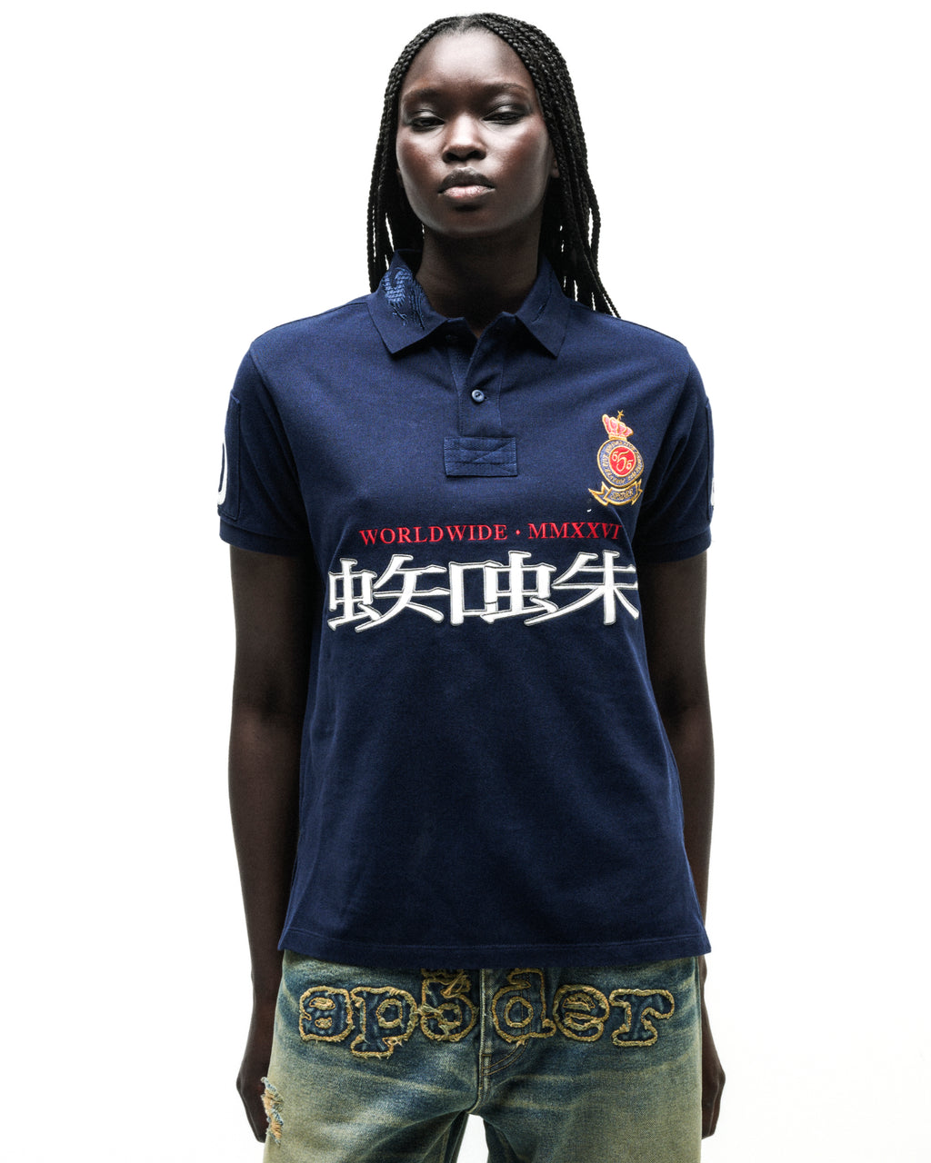 Navy blue polo shirt with "WORLDWIDE • MMXXVI" and white Japanese characters, red crest, and distressed denim.