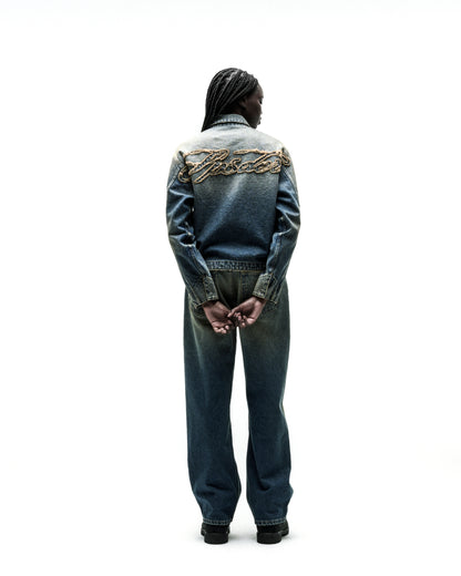 Washed blue denim work jacket with "SCRIPT" embroidery on back, paired with matching jeans.