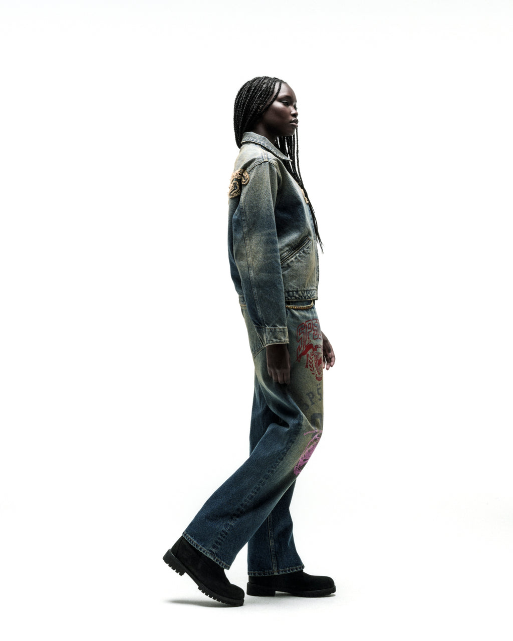 Worn-in blue denim work jacket and matching jeans with red and pink script embroidery.