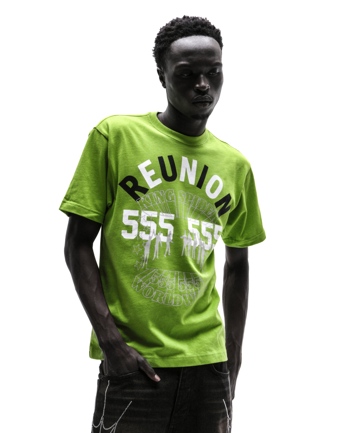 Model wearing a lime green graphic t-shirt with white and black text, paired with black jeans against a white background.