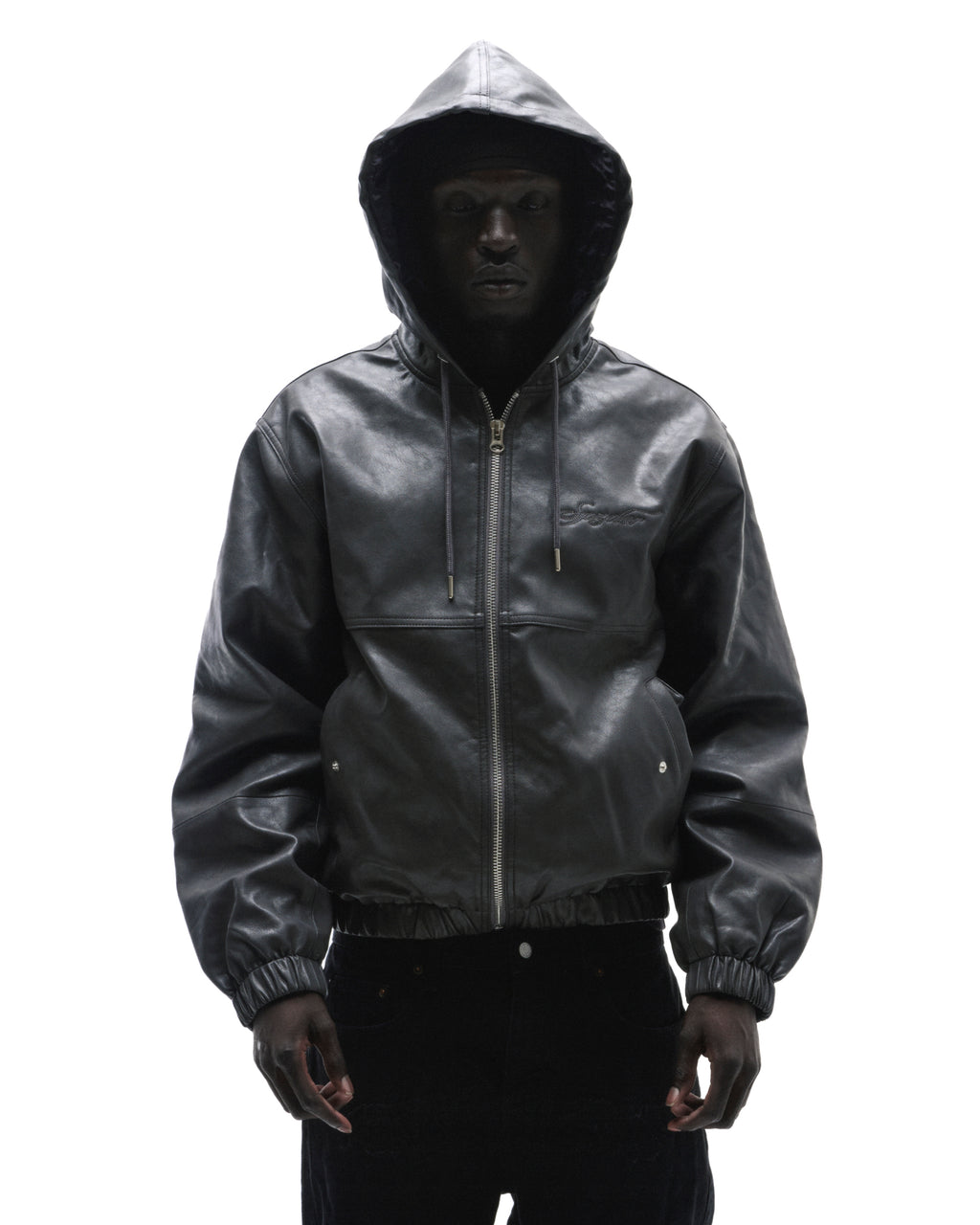 A model wearing a black leather zip-up hooded jacket with a subtle embroidered logo against a white background.