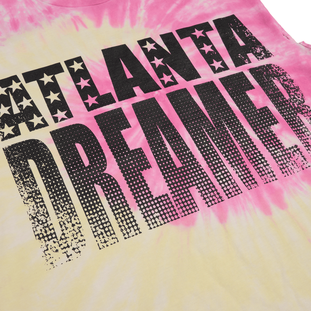 Pink and yellow tie-dye cotton tank top with "ATLANTA DREAMER" graphic print and raw-cut armholes.