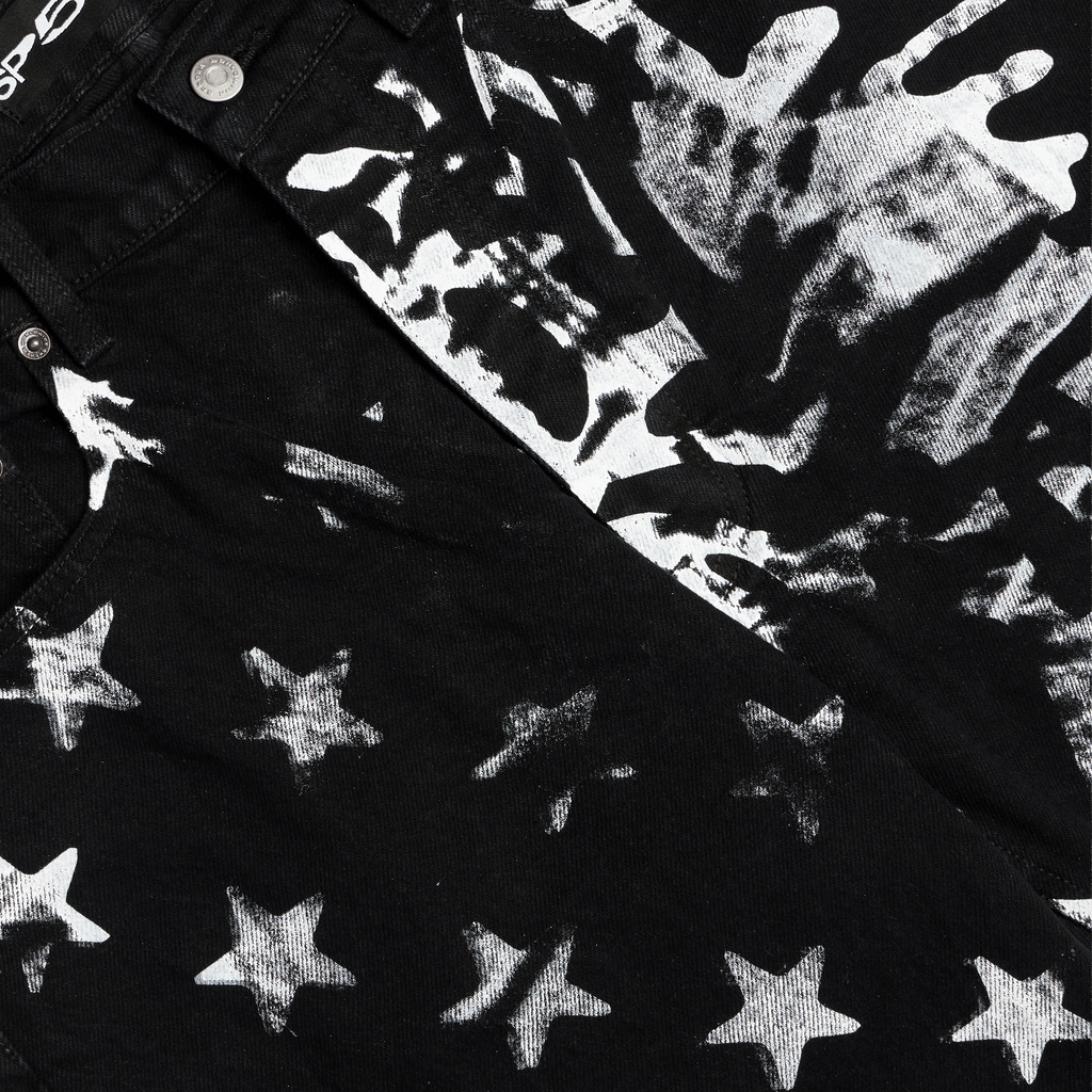 Black denim pants with white stars and web graphic print.