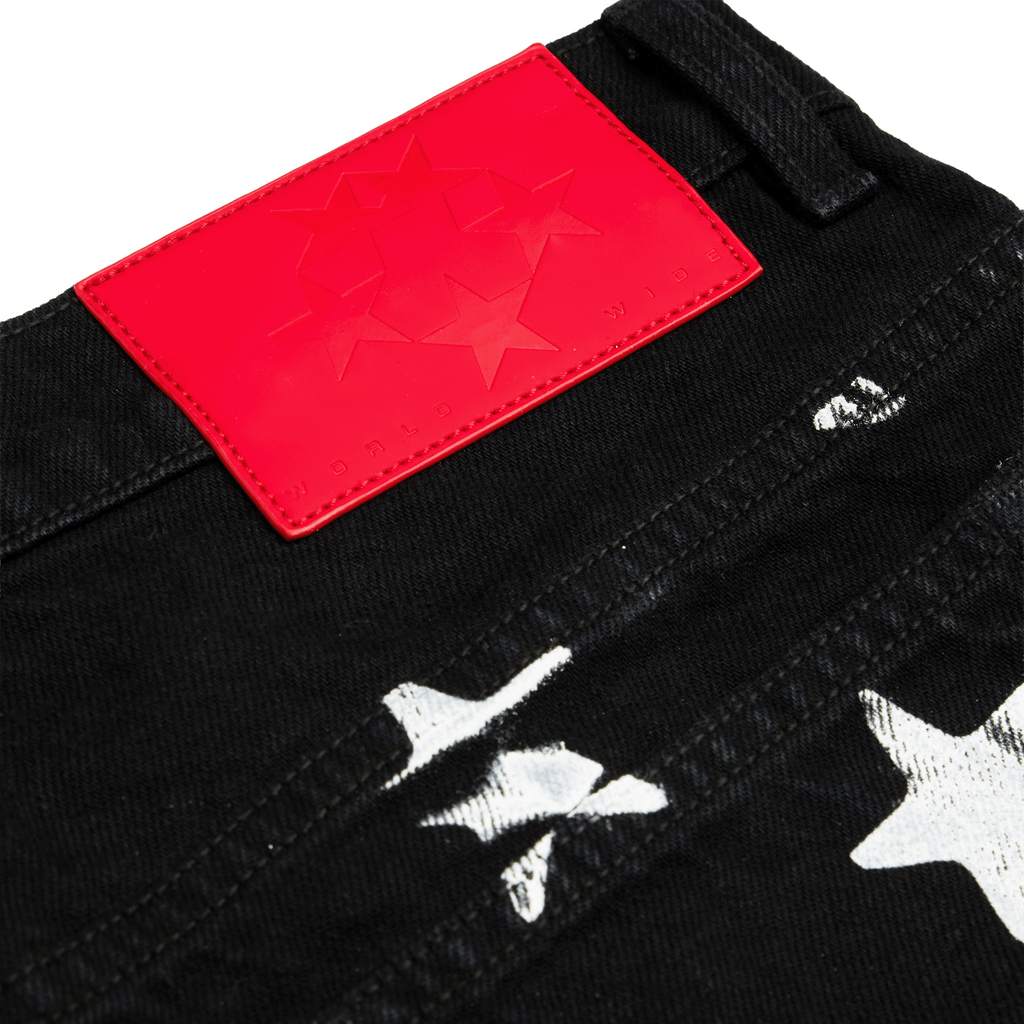 Black denim pants with white stars and web graphic print.