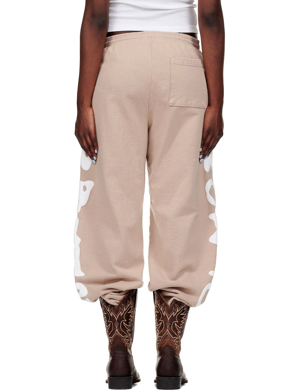 Sand Beluga Sweatpants with white puff print "Worldwide" text, worn by a female model in size M.