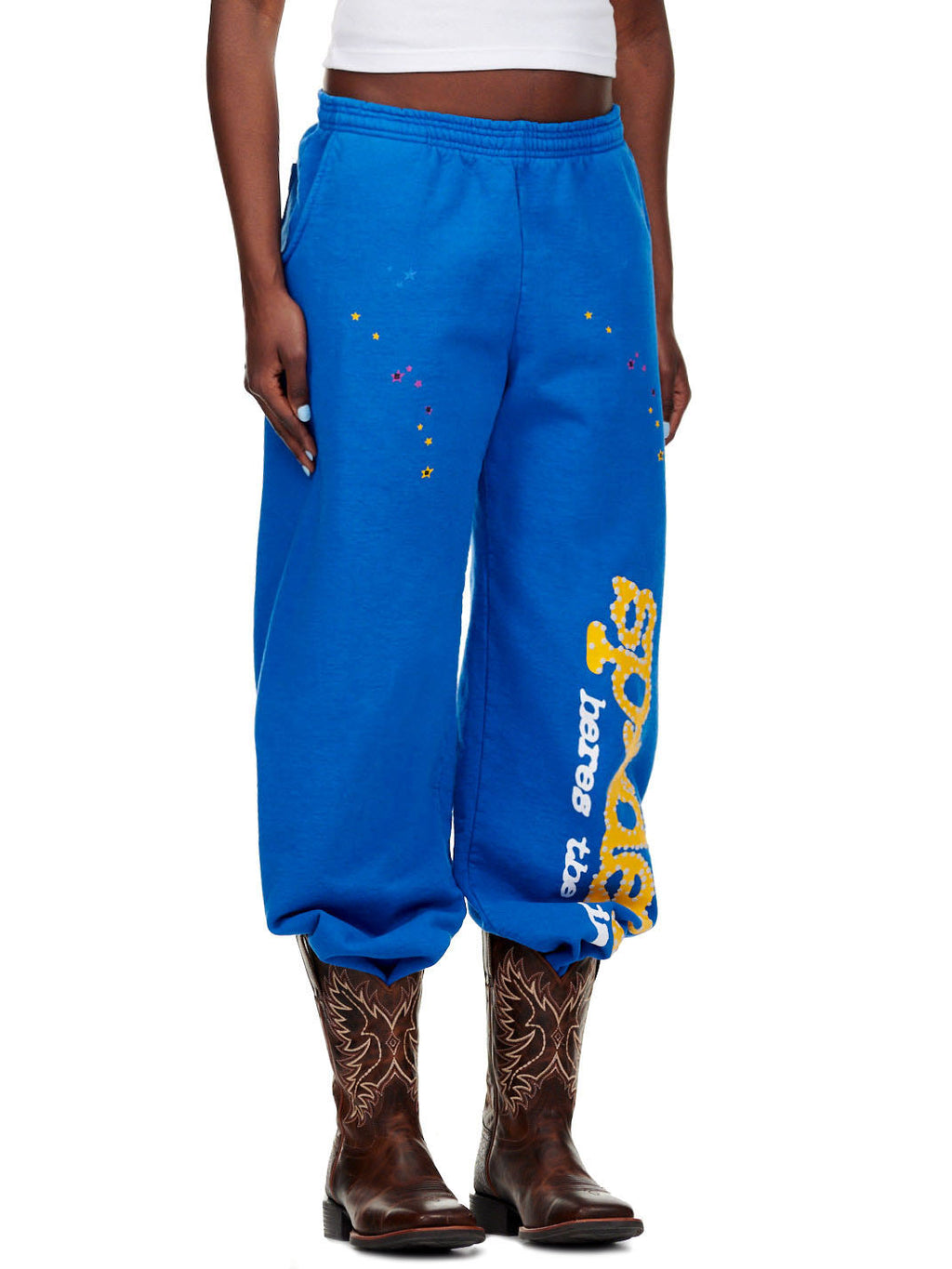 TC BLUE SWEATPANT, 23oz fleece with SP5DER! text and star puff/discharge print, worn with cowboy boots.