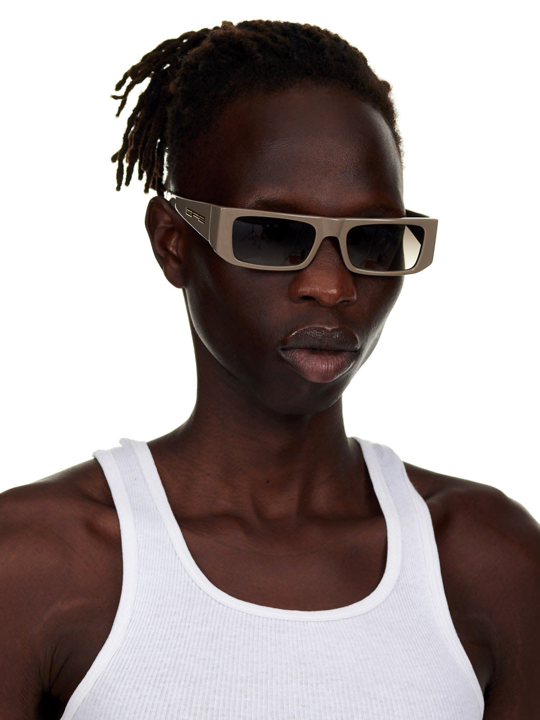 Model wearing SP5 x FLATLIST EYEWEAR 'SLUG' sunglasses with smoke brown gradient lenses and a matte taupe acetate frame.