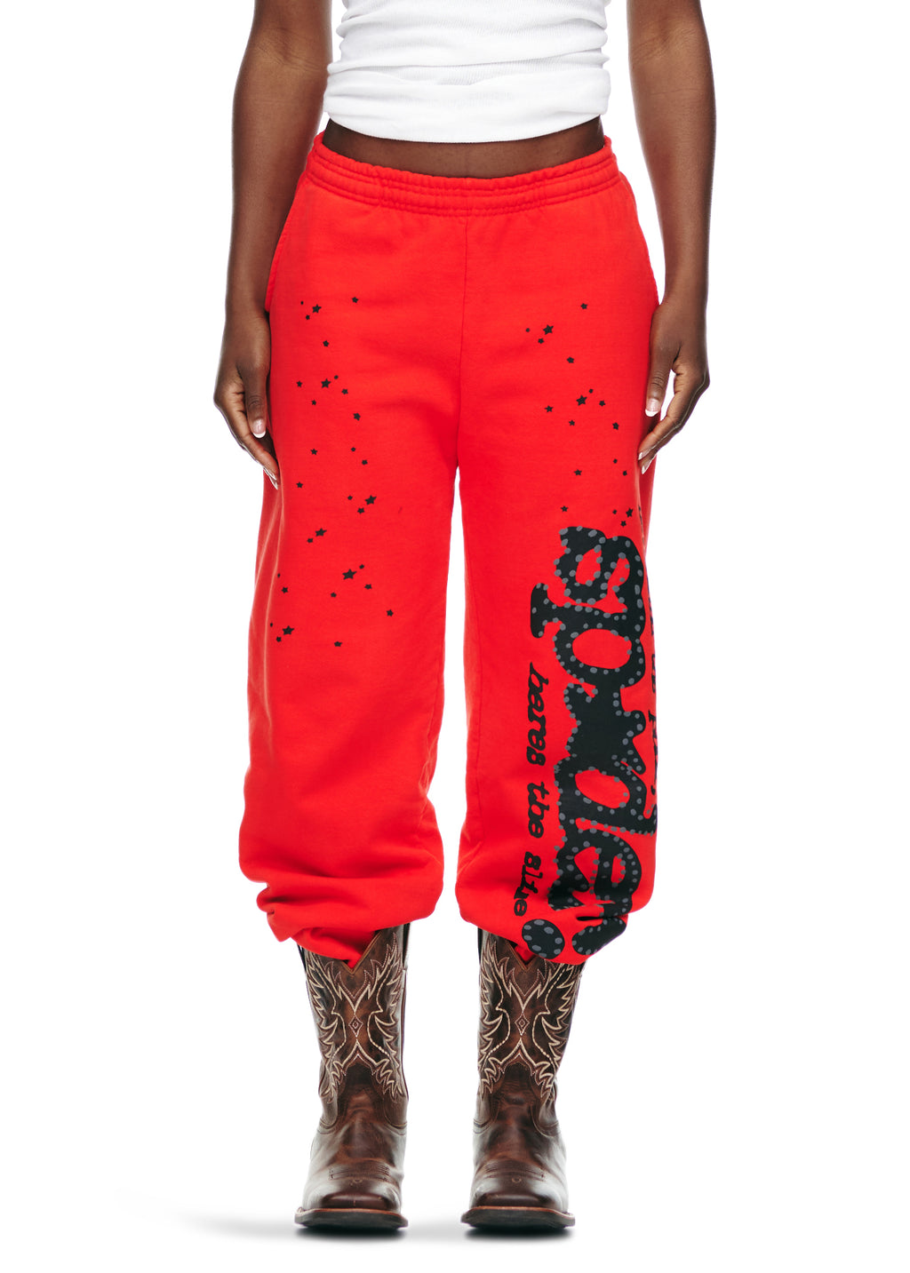 Red P*NK V2 sweatpants with black puff print SP5DER motif, star prints, and elastic cuffs.
