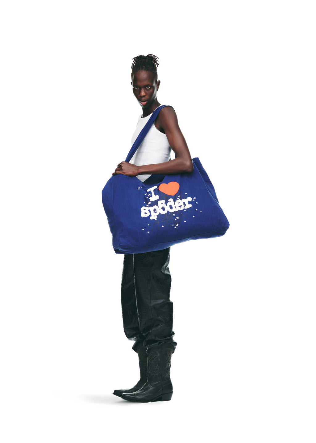 Model holding a large navy blue Souvenir XL Tote with "I ♥︎ SP5DER" jumbo print.
