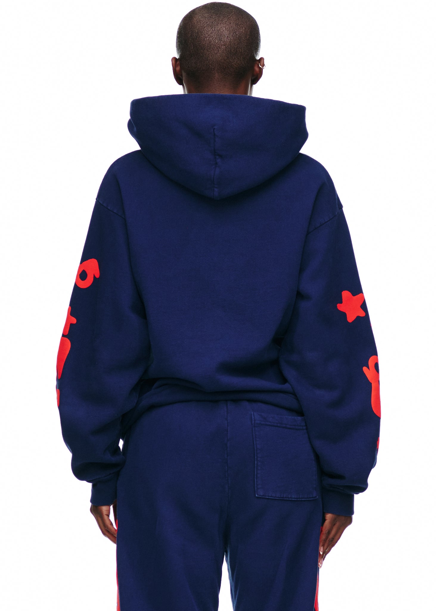 BELUGA HOODIE: Navy 23oz fleece hoodie with red puff print stars on sleeves, worn by a person from behind.