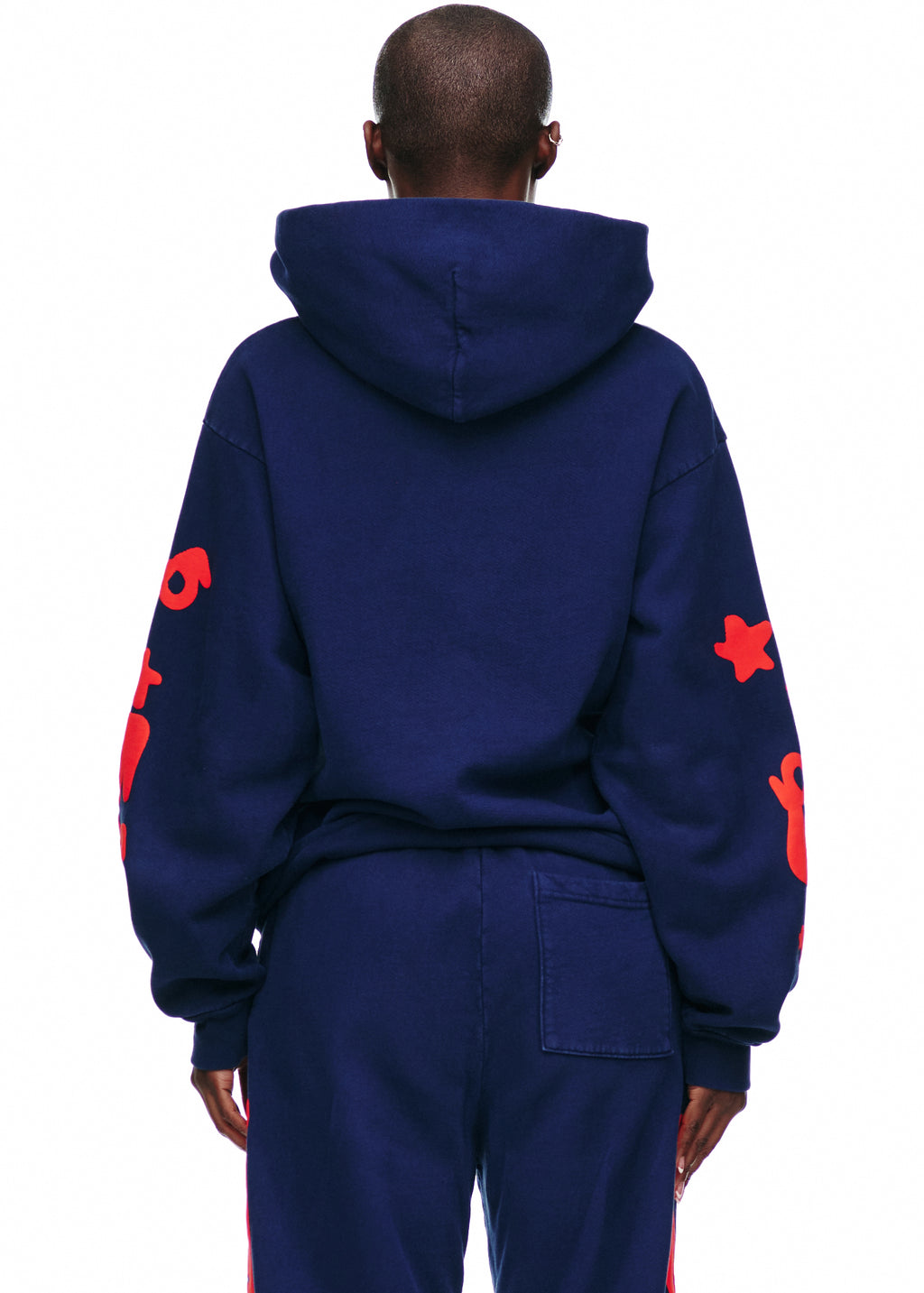 BELUGA HOODIE: Navy 23oz fleece hoodie with red puff print stars on sleeves, worn by a person from behind.