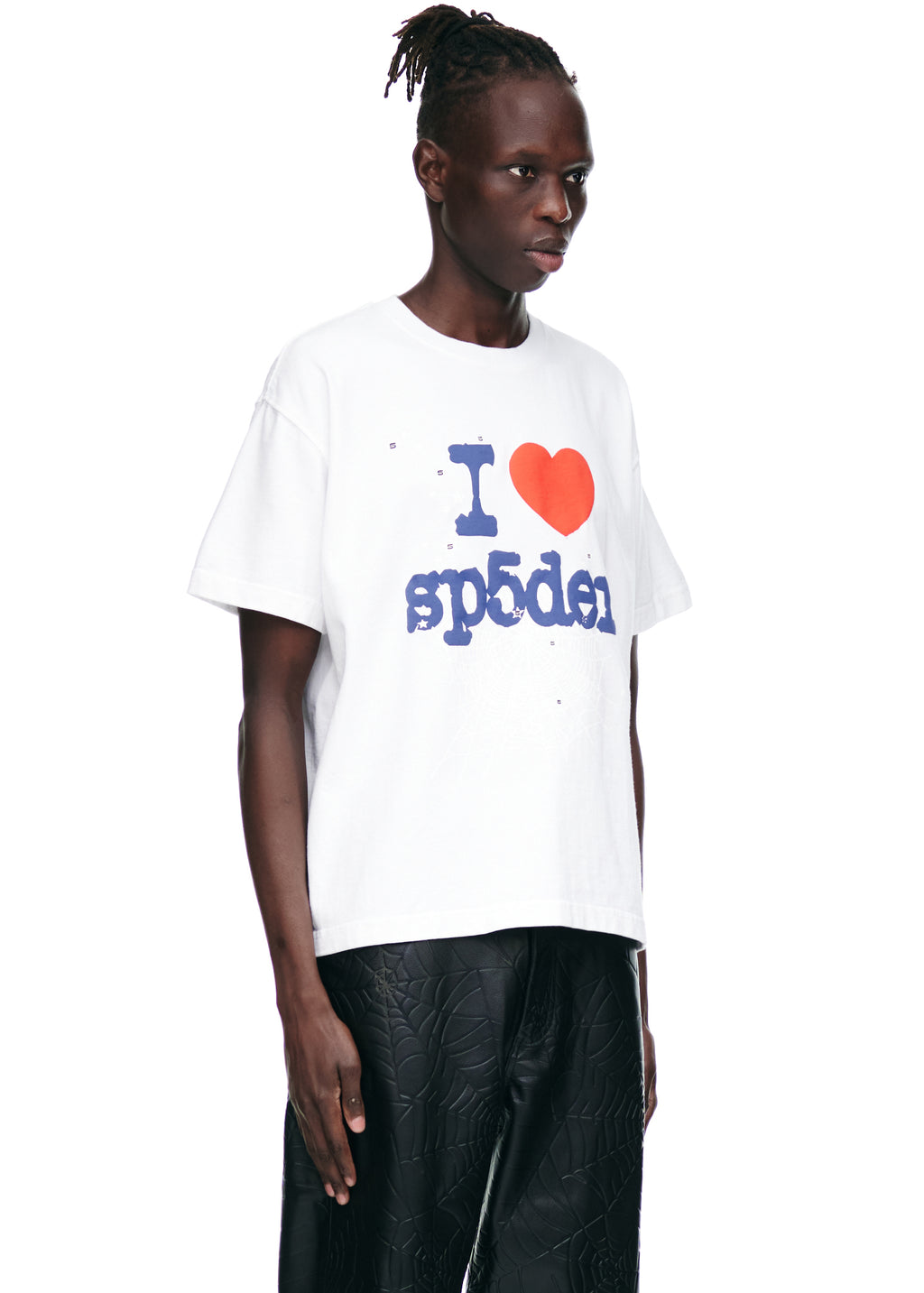 Male model in white 100% cotton "I ❤️ sp5der" graphic tee and black textured pants.