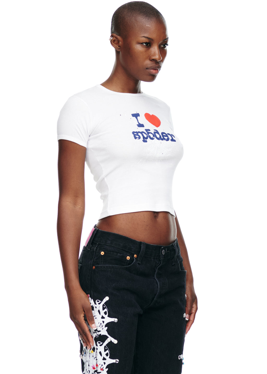 Female model in white 100% cotton cropped baby tee with "I ❤️ SP5DER" graphic, paired with black jeans.