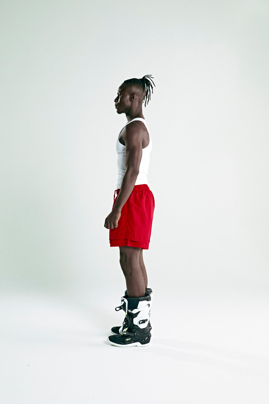 Man in red OG WEB DOUBLE LAYER SHORT with high-low design, OG SP5DER text, and star print.