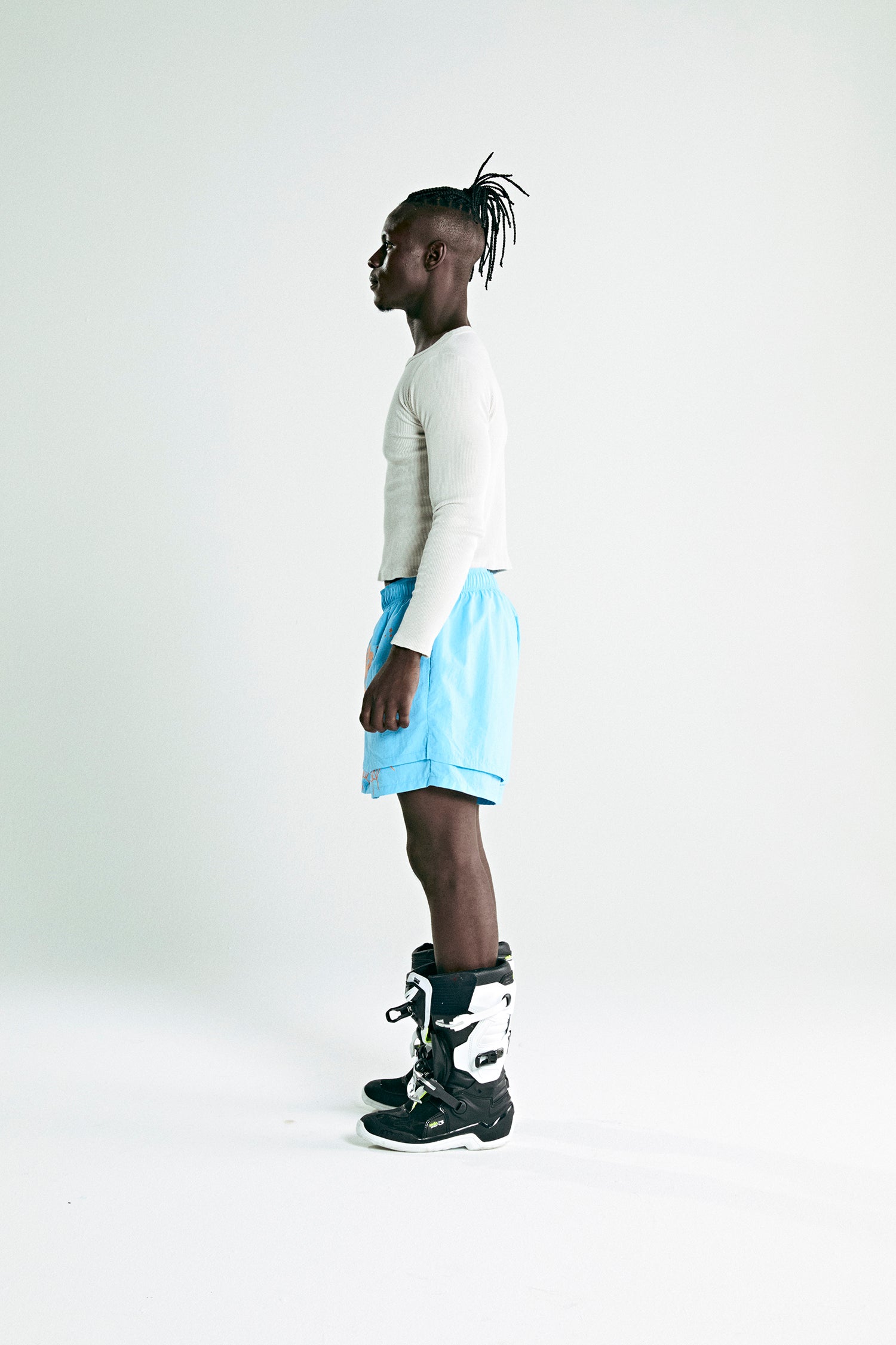 Man in light blue OG WEB DOUBLE LAYER SHORT with OG SP5DER text and star print, made of water repellent nylon.