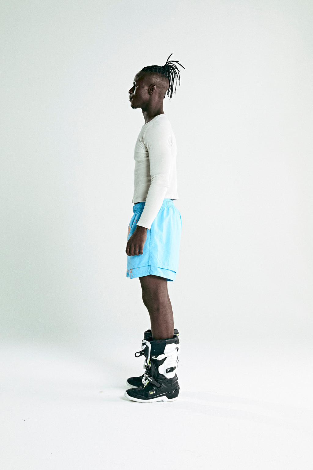 Man in light blue OG WEB DOUBLE LAYER SHORT with OG SP5DER text and star print, made of water repellent nylon.