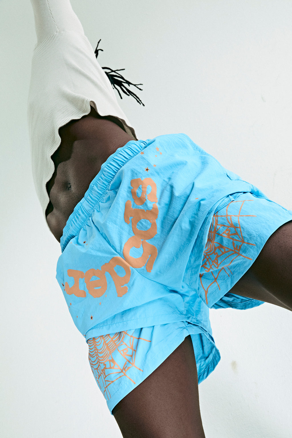 Blue nylon double-layer shorts with orange "OG SP5DER" text, star, and spiderweb prints.