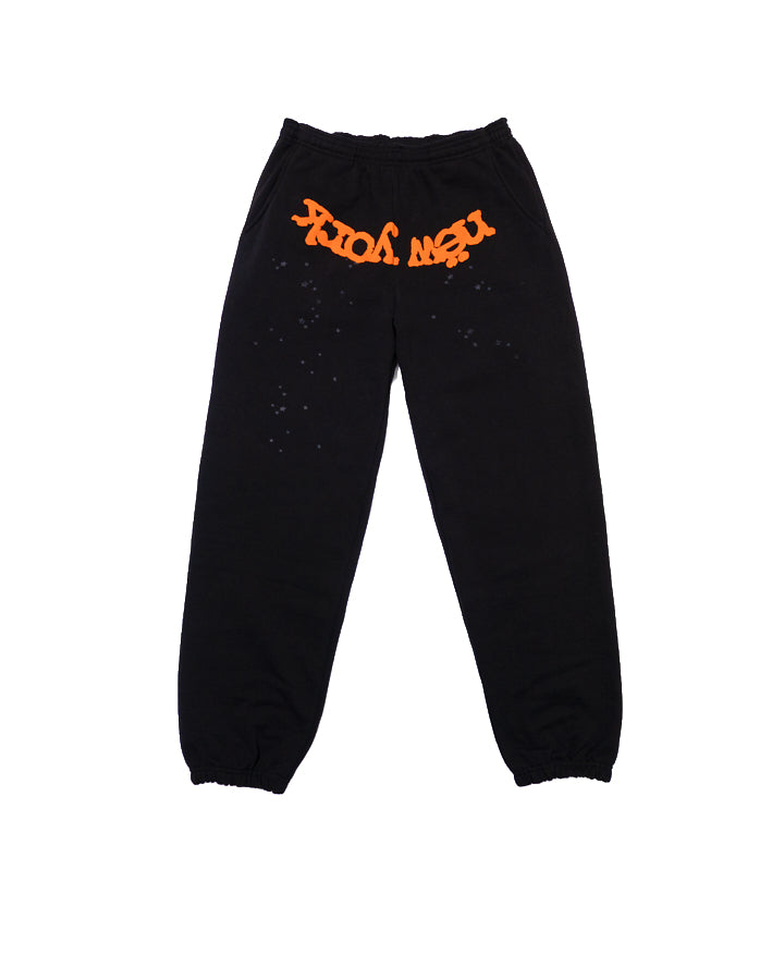 Black cotton fleece sweatpants with orange "NEW YORK" puff print at crotch and discharge print spots.