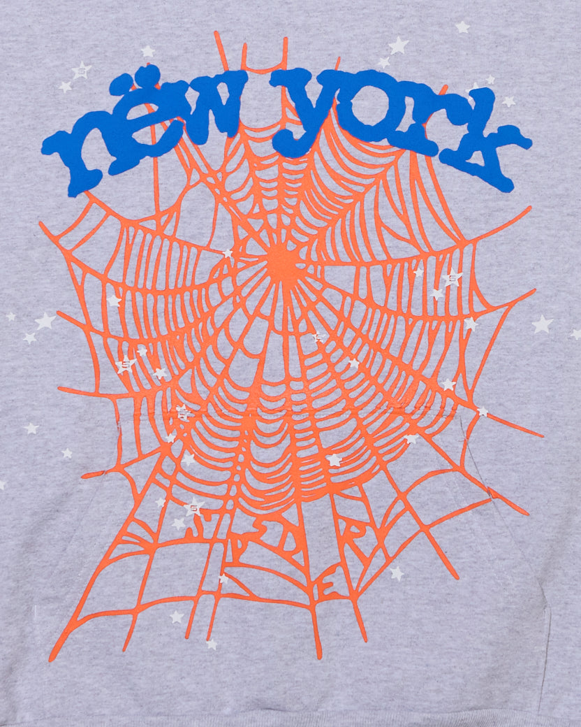 Gray OG WEB V2 HOME HOODIE with orange spiderweb and blue "new york" puff print, surrounded by small stars.