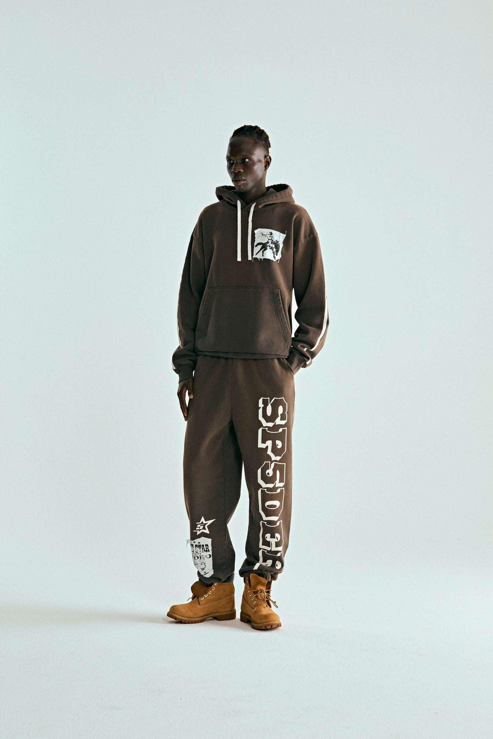 Brown 5STAR Rodeo hoodie and sweatpants set with distressed patches, worn by a man.