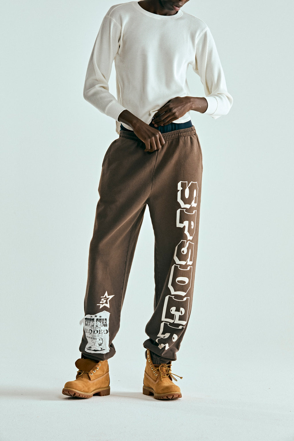 Brown 5STAR RODEO SWEATPANT with white SP5DER text, side stripe, and distressed patch.